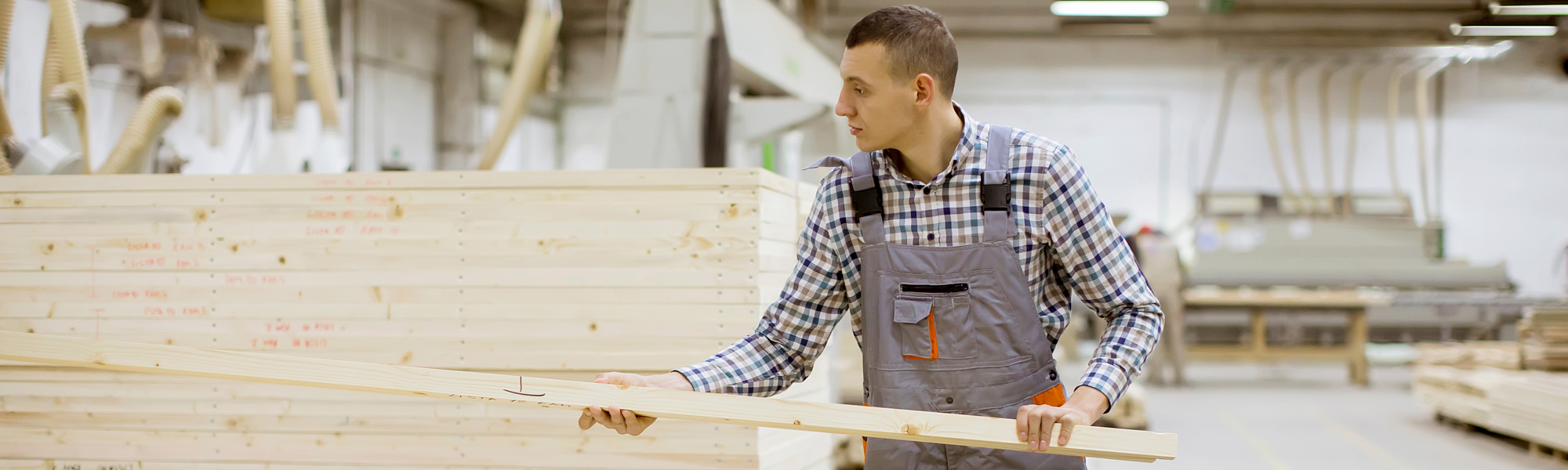 Disabled young man with an artificial leg is working at the furniture factory