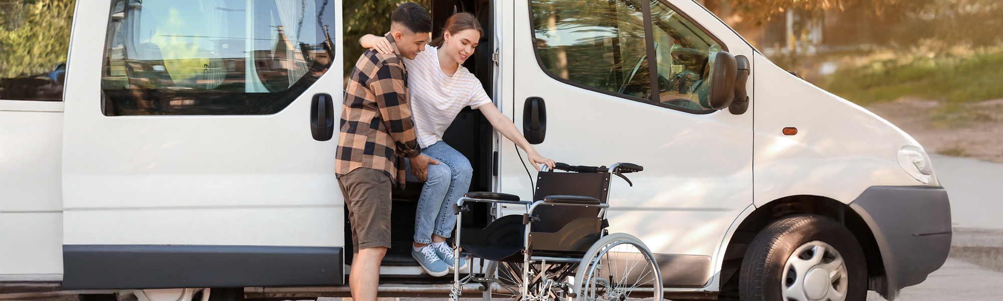 Man helping his handicapped wife to get out of van