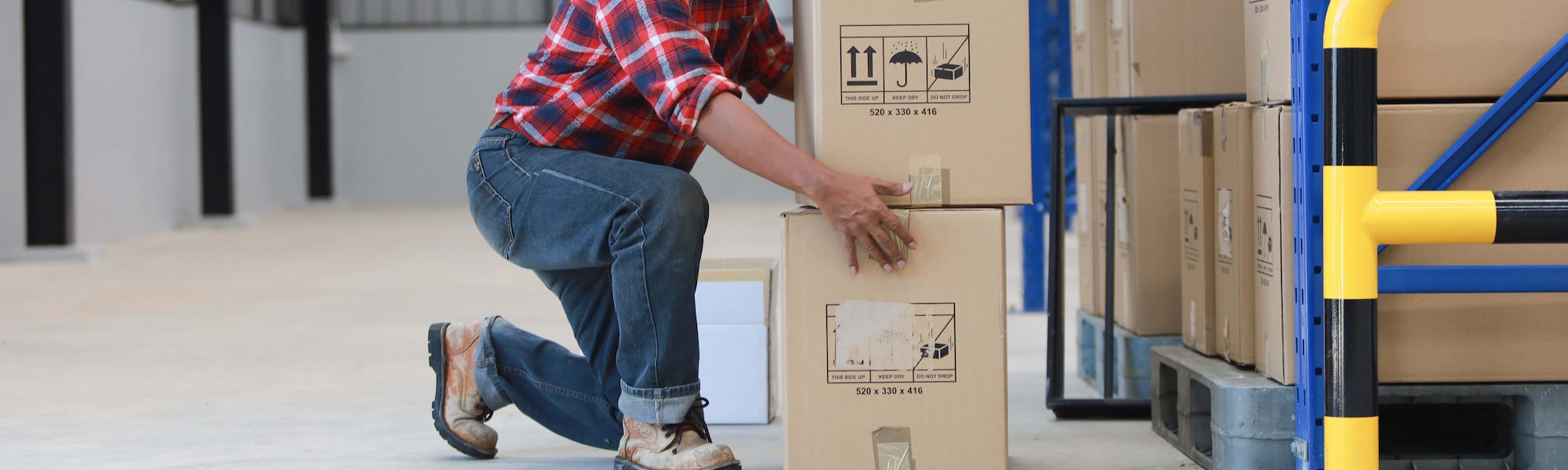 asian worker man hurt his back lift heavy box in factory