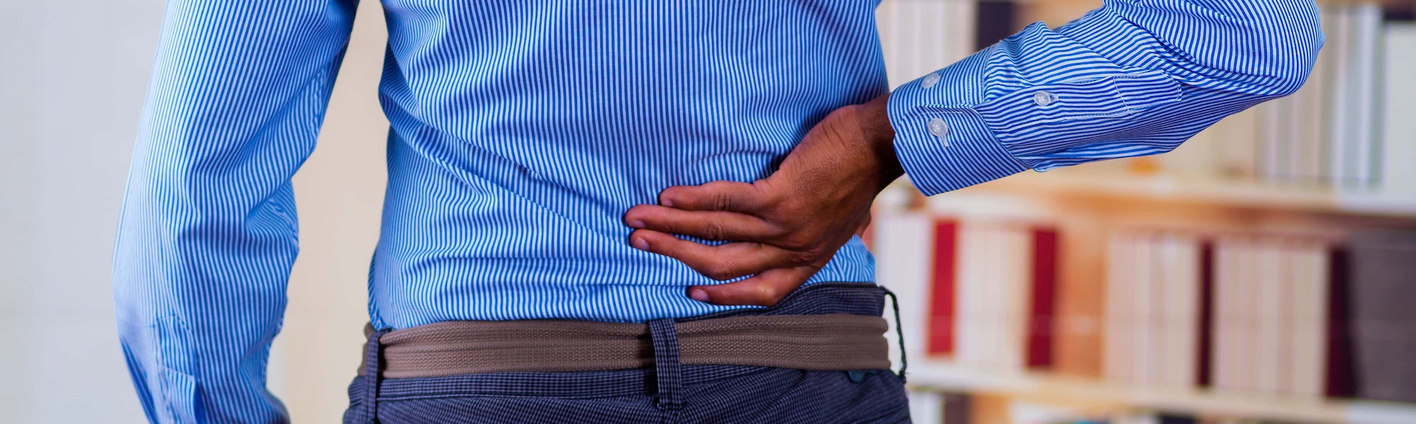 man touching his back with one of his hand back pain