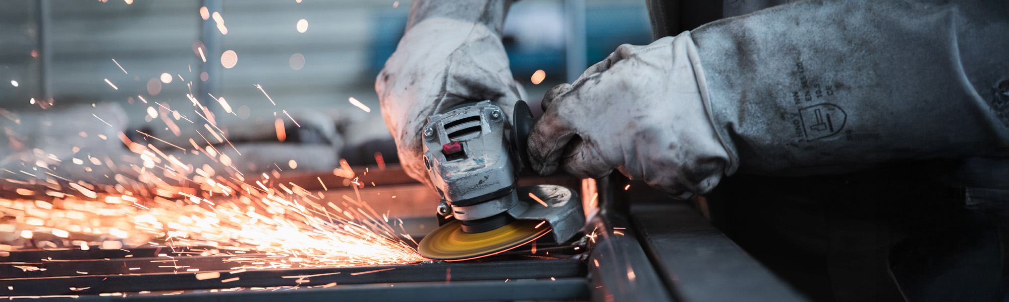 person grinding metal with sparks flying out