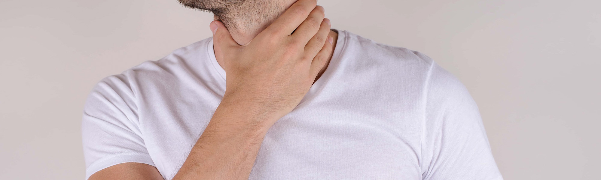 portrait of bearded with stubble guy holding touching painful neck wear white t shirt
