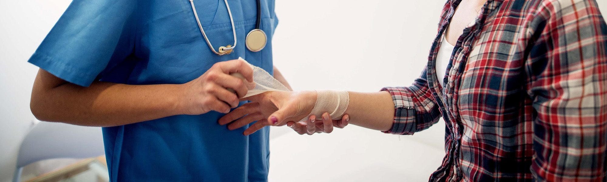 professional carry medical nurse putting a bandage on a young girls injured hand