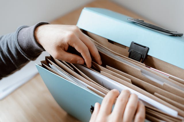 person looking through folder for papers