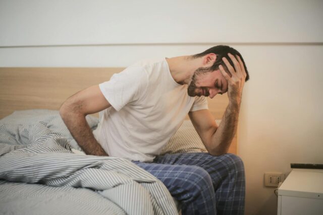 injured man waking up holding head and back